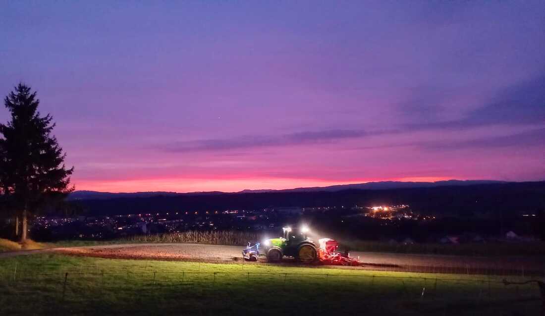 Traktor in der Abendsonne auf dem Feld beim Stiegelehof
